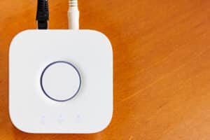 Smart Home Hub in white for home automation on brown wooden desktop with copyspace.